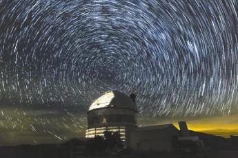 Star trails swirl around Polaris, the North Star, above the Hobby-Eberly Telescope. Photo by Ethan Tweedie Photography.